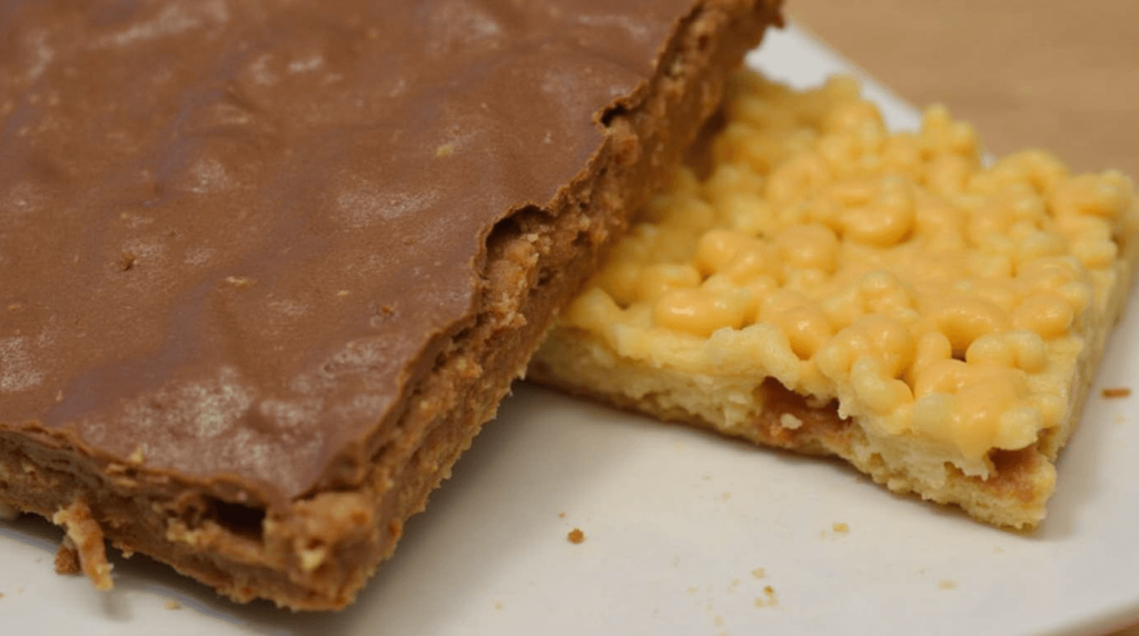 Chocolate-coated Cheez-It peanut butter treats garnished with sea salt on parchment paper."